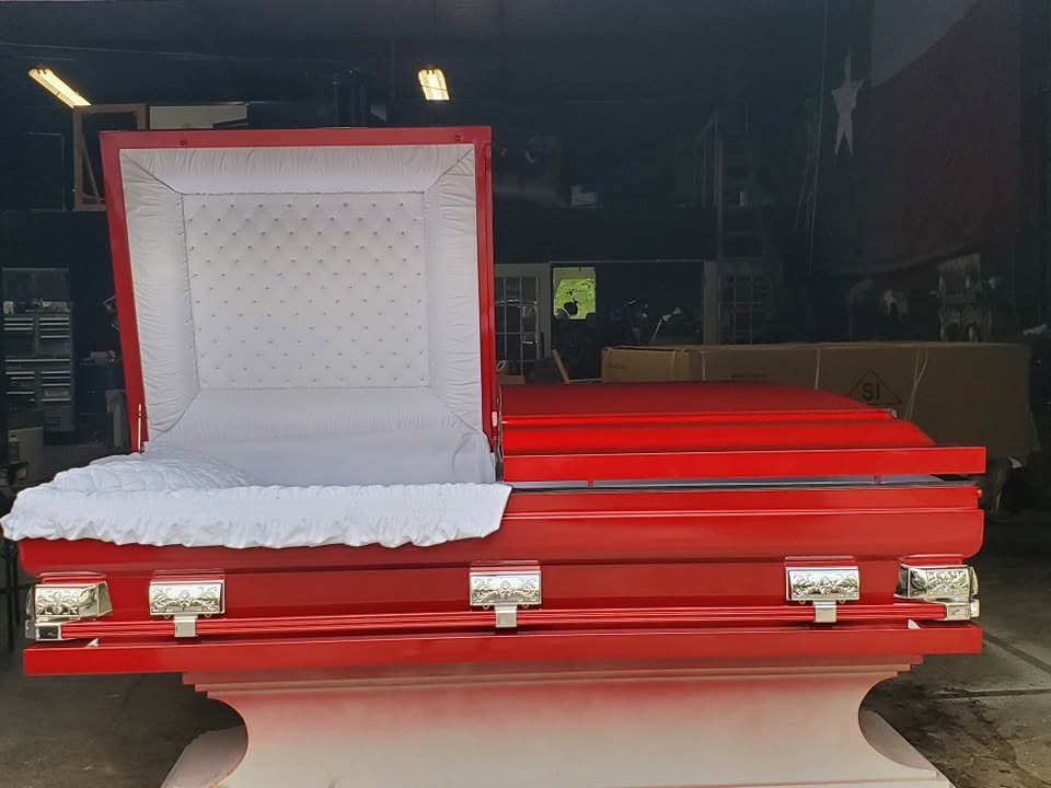 Fire red casket open to show tufted white crepe lining inside the SoulShine fabrication shop
