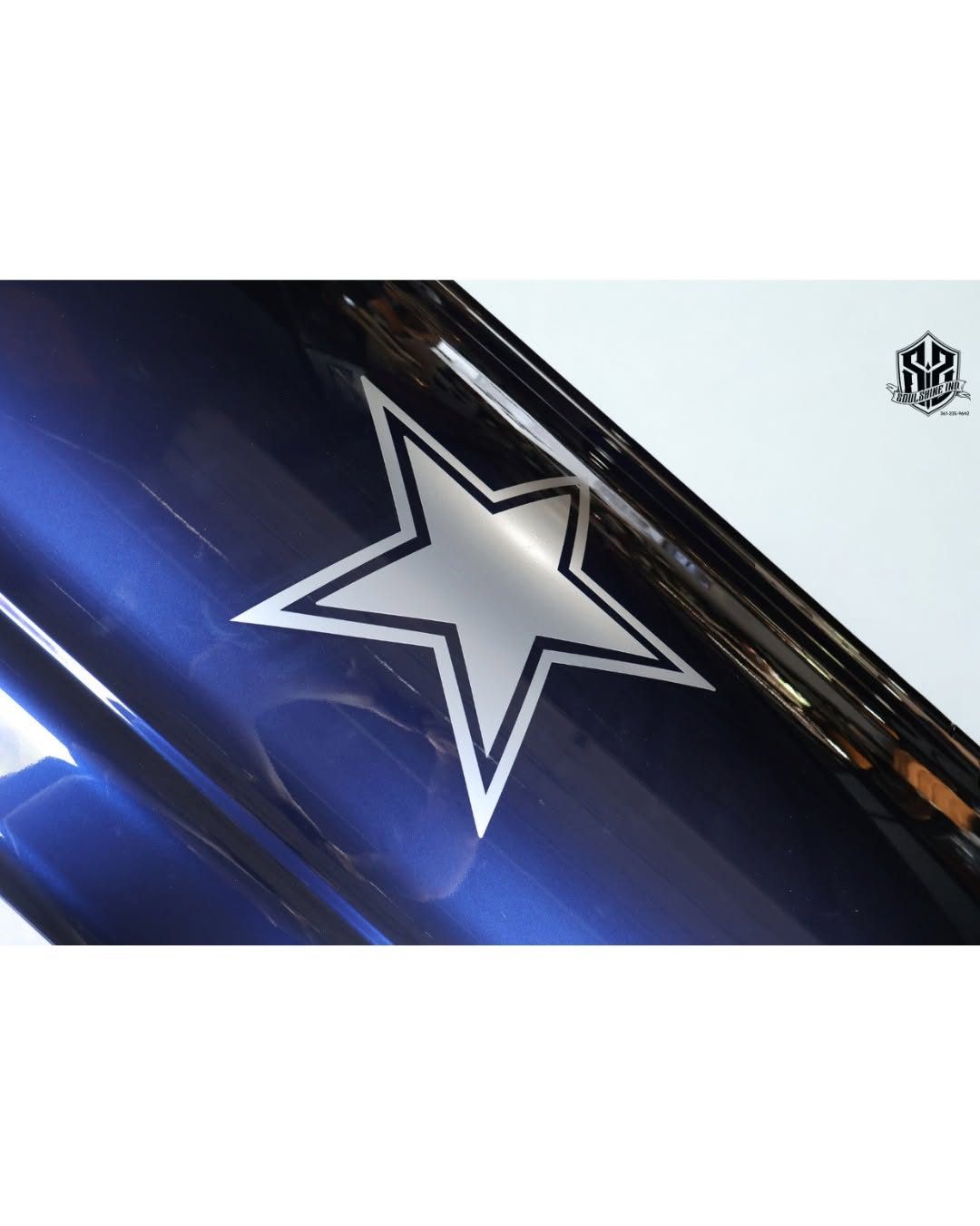 Close up of a metallic navy casket lid carrying a chrome silver Dallas Cowboys star