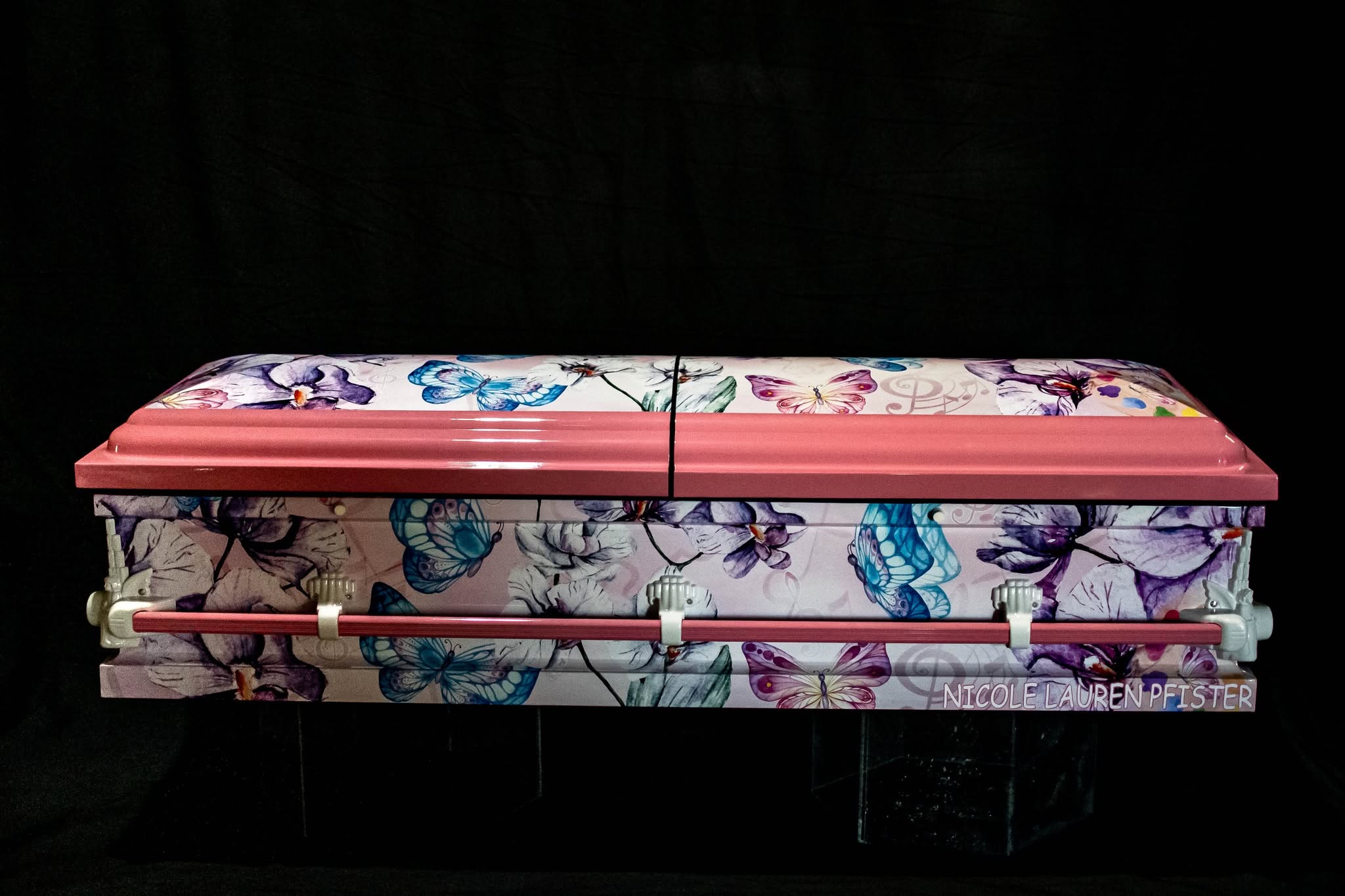 Pink casket covered in watercolor butterflies and orchids, named for Nicole Lauren Pfister