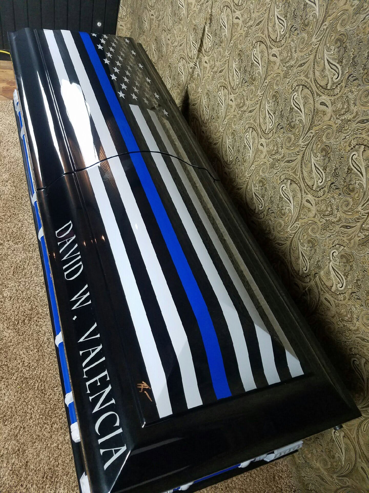 Thin blue line American flag casket lettered DAVID W. VALENCIA in bold white script