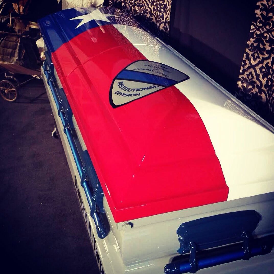 Texas flag wrapped casket carrying a Texas Department of Criminal Justice Institutional Division seal