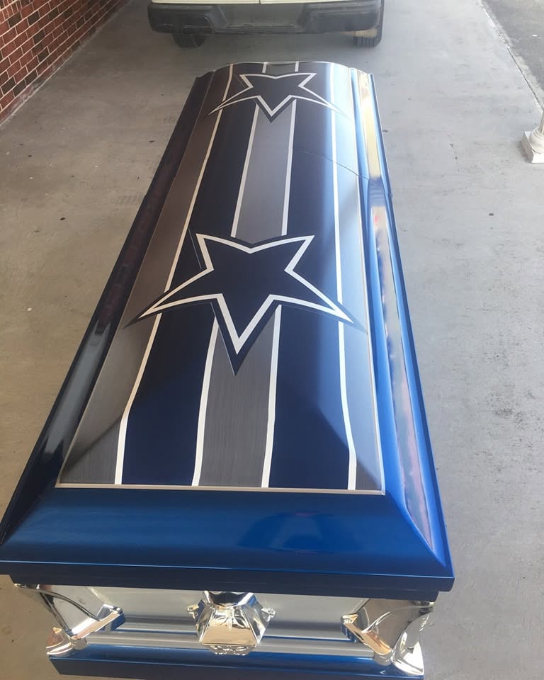 Metallic navy casket striped in silver with two Dallas Cowboys stars and chrome corner handles