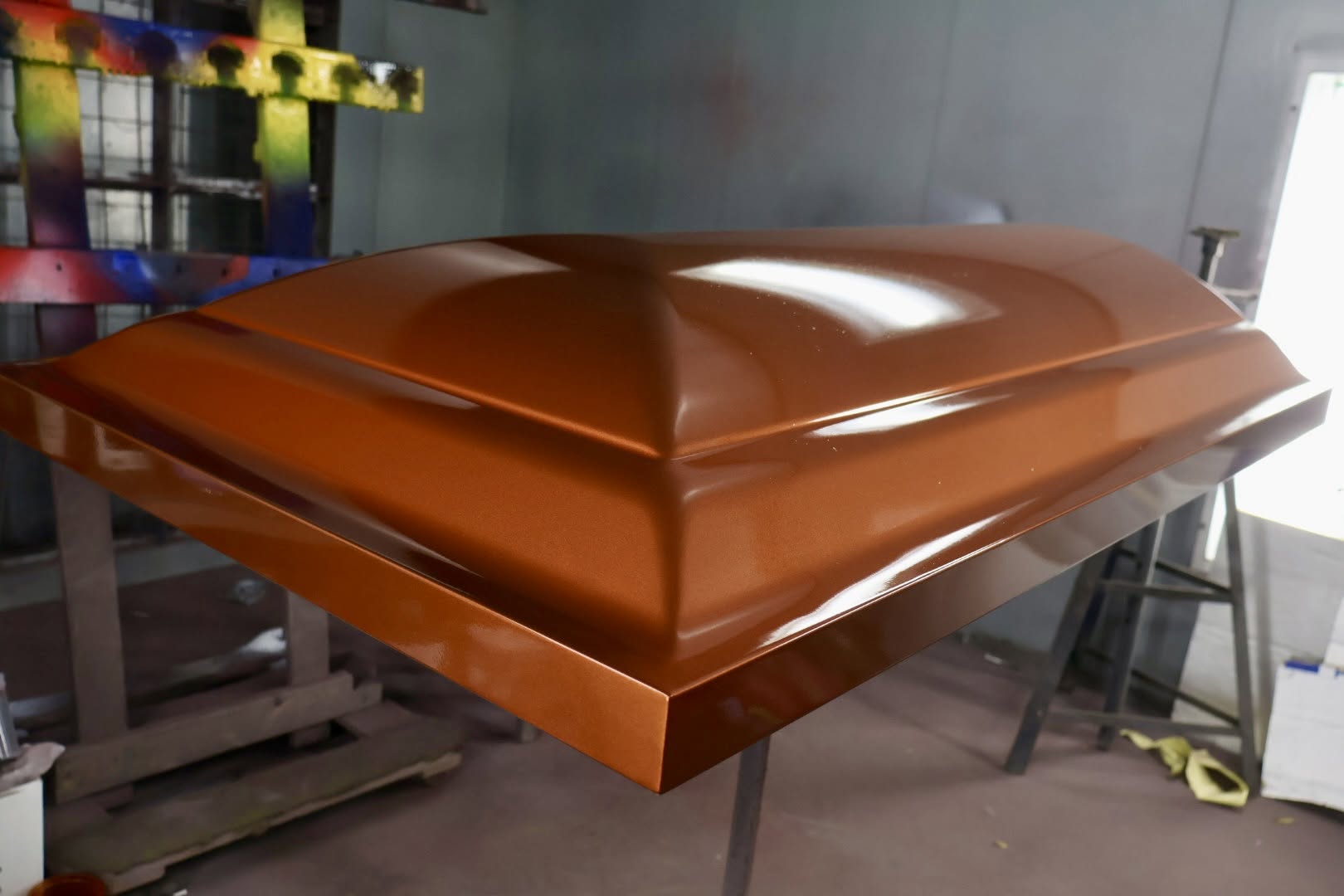 Copper metallic casket lid gleaming on stands inside the SoulShine design shop