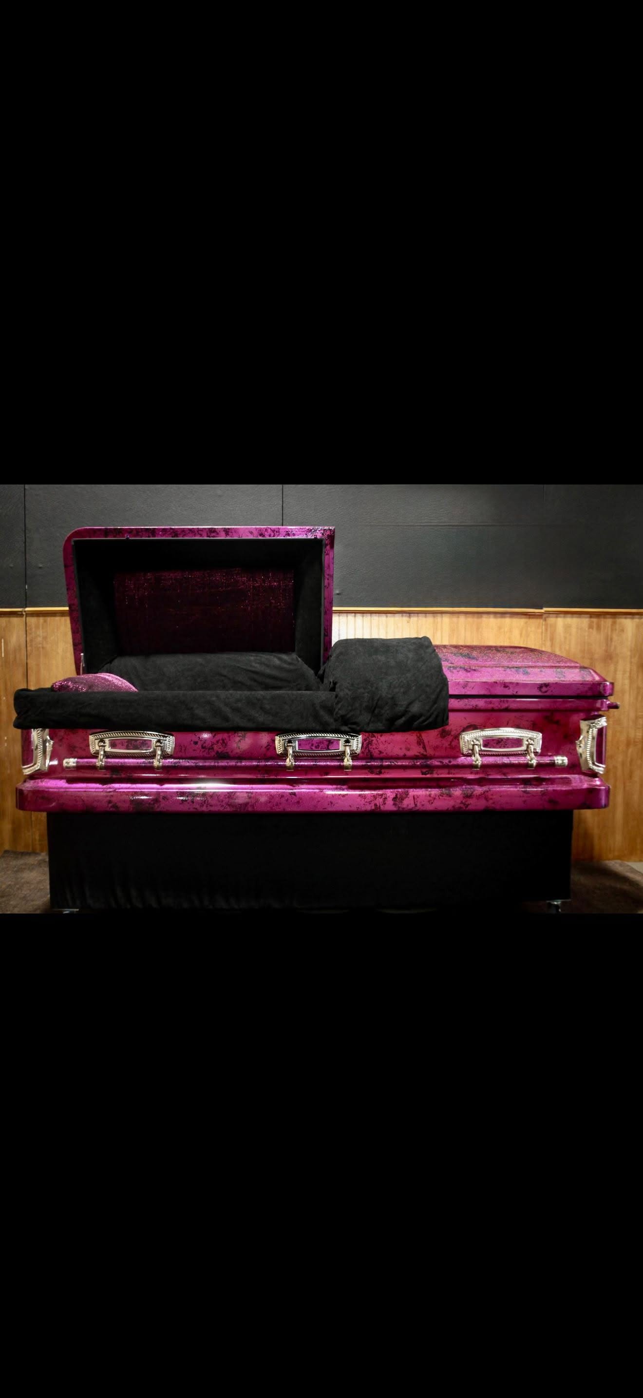 Open magenta casket in a marbled pink finish with chrome handles and black velvet interior