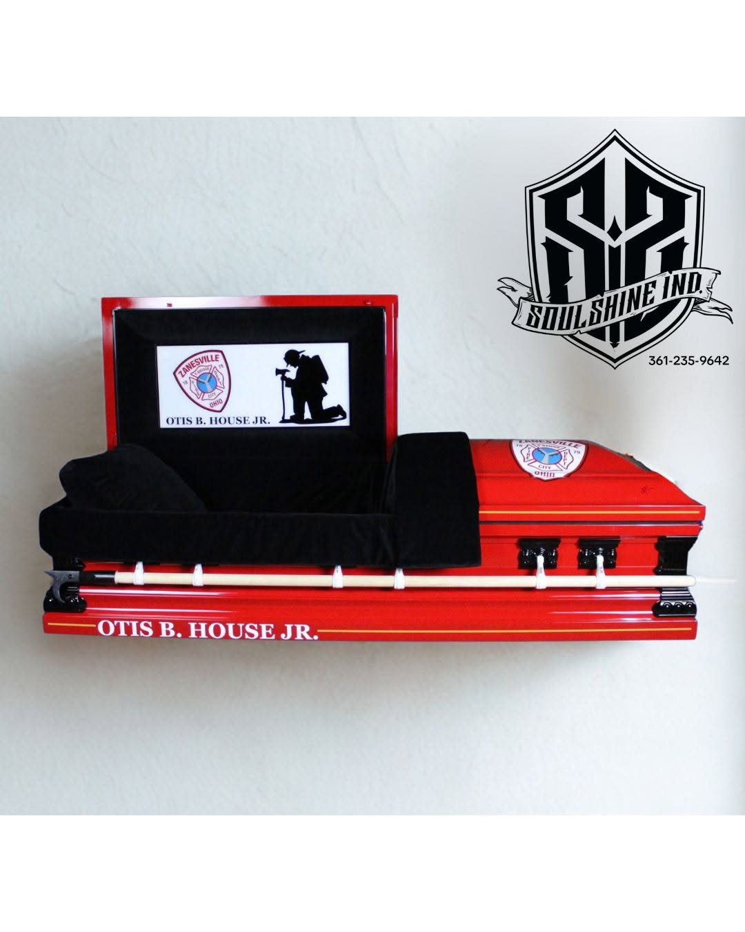 Fire engine red casket lettered OTIS B. HOUSE JR. with a Zanesville fire department seal