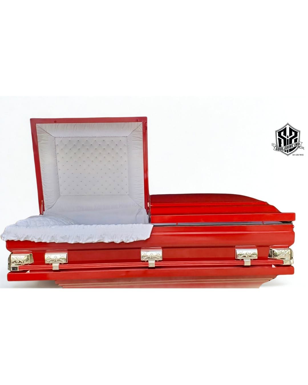 Bright red high gloss casket opened to a white crepe interior with silver swing bar handles