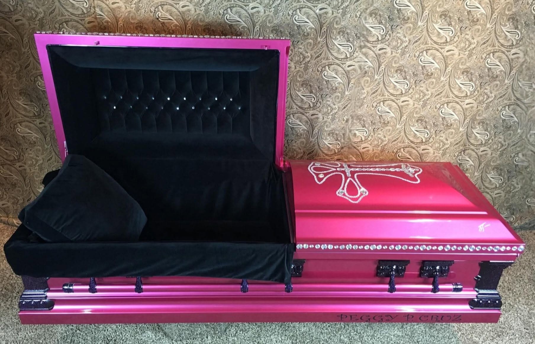 Hot pink metallic casket with a rhinestone cross, crystal trim and black velvet interior