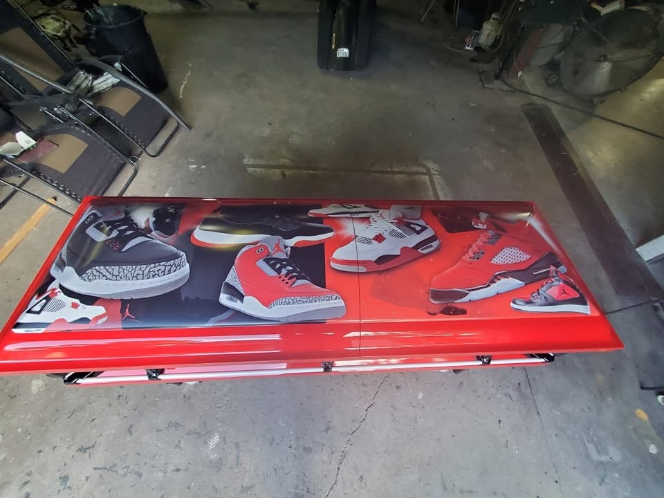 Bright red child casket wrapped with Air Jordan sneaker artwork across the full lid