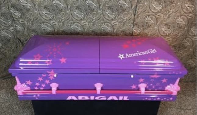 Purple child casket with pink stars, an American Girl logo and the name Abigail in white