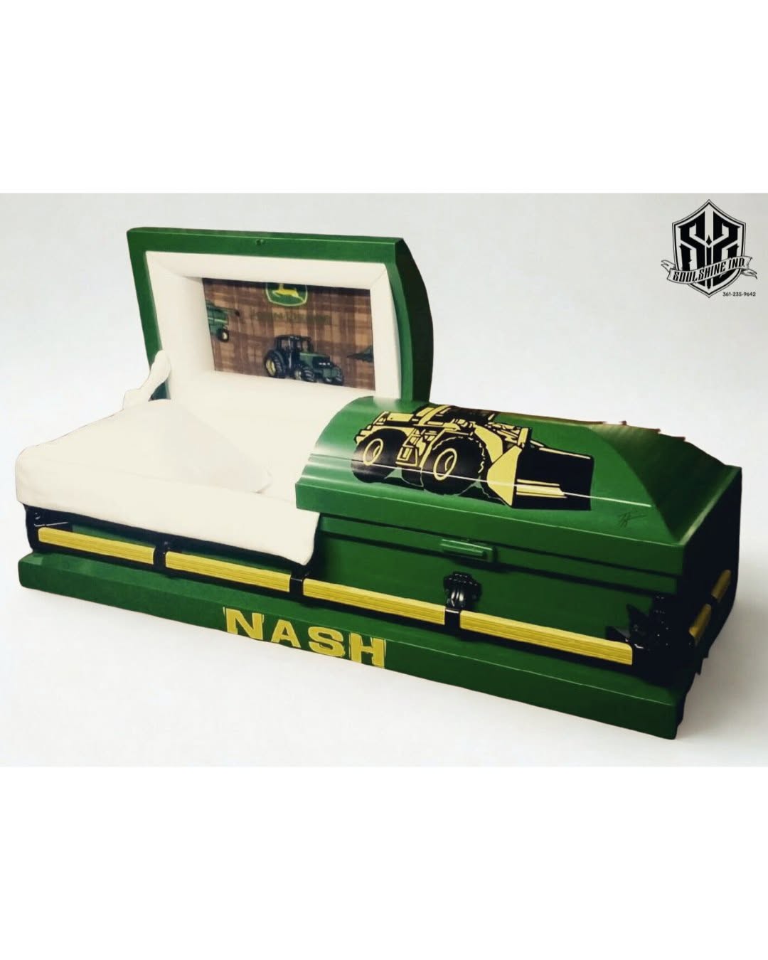 Green John Deere tractor child casket lettered NASH, open to show its cream crepe interior