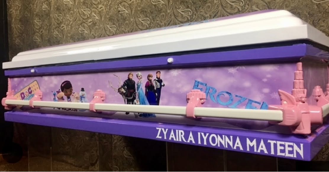 Purple Frozen themed child casket with a white lid, pink handles and Zyaira Iyonna Mateen lettering