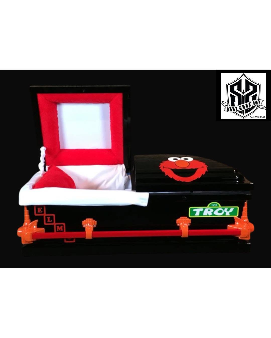 Black child casket with an Elmo face, red handles and a green nameplate reading Troy